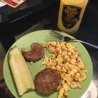 Two eggs, Two sausage pattys, one spear pickle, and glass of orange juice.|kevin brett maysonさん