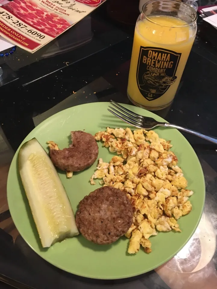 Two eggs, Two sausage pattys, one spear pickle, and glass of orange juice.|kevin brett maysonさん