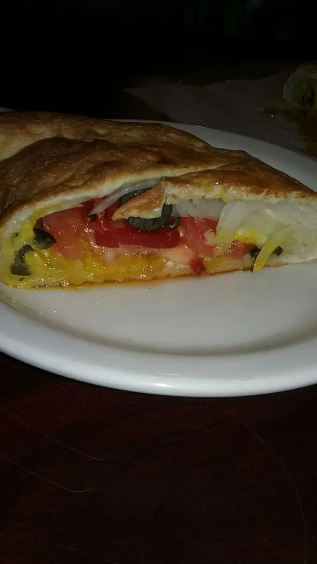 Snapdishの料理写真:calzone lunch at work. with tomatoes, onion, mustard,  olives, and hot peppers.  so good.|Polly Gelfusoさん