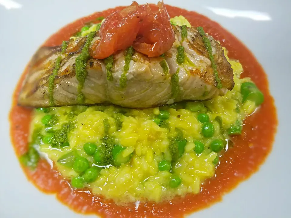 Grilled Atlantic Salmon over saffron risotto with oeas and asapargus. Finished with a basil pesto drizzle and roasted tomato.|Melissa Greenさん