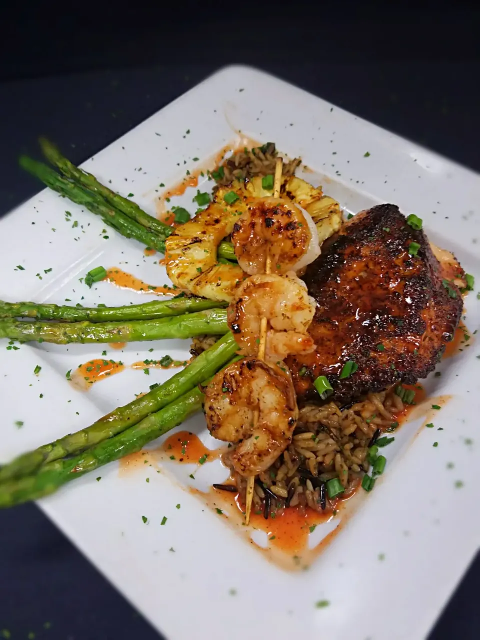 Tropical Salmon & Shrimp. A blackened salmon filet and 3 grilled shrimp served over a bed of wild rice, grilled asapargus and topped with a pinneapple ring. Gen|Melissa Greenさん