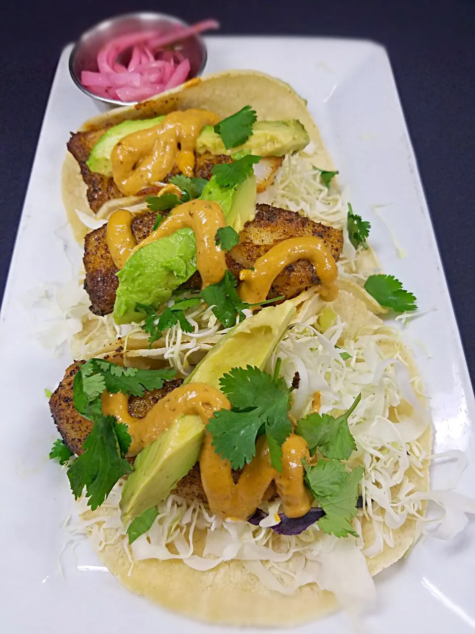 Cod tacos, filled with shredded cabbage, topped with a chiptole remo and cilantro.|Melissa Greenさん