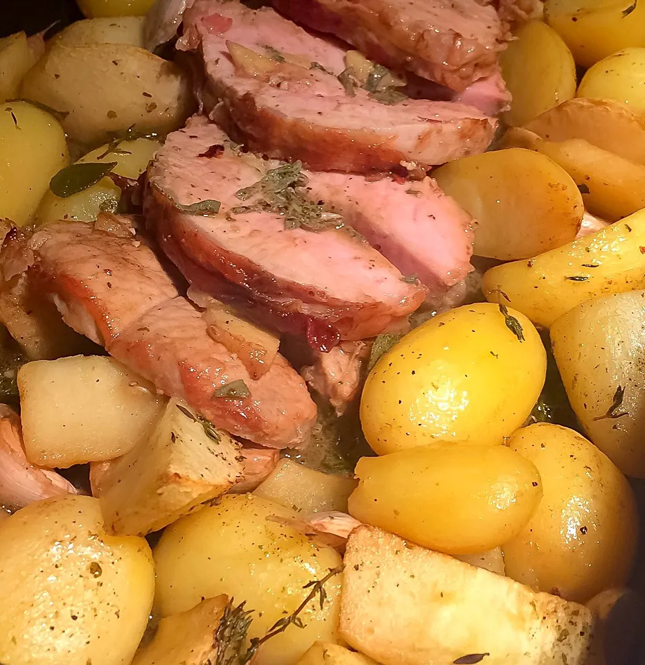 Oven Dish made of lean pork rollade wrapped in pancetta, flambé in Calvados. Cooked with potatoes, apple parts an lots of garlic cloves|Johan van de Beekさん