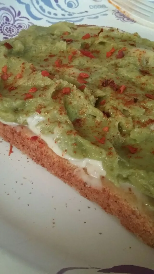 spicy guacamole on buttered,  mayonnaised oatmeal bread.|Polly Gelfusoさん