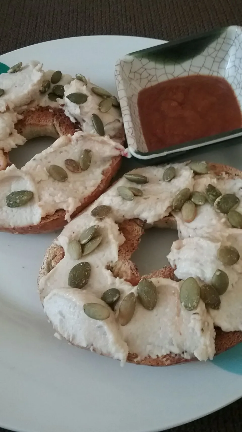 spinach bagel with white bean hummus and lightly salted pumpkin seeds.|Polly Gelfusoさん