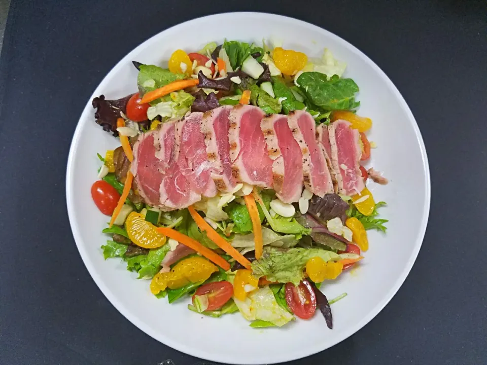 Snapdishの料理写真:seared ahi tuna salad. Field greens, cucumbers, tomato, carrots, sliced almonds ans mandarian oranges. served with a honey ginger dressing.|Melissa Greenさん