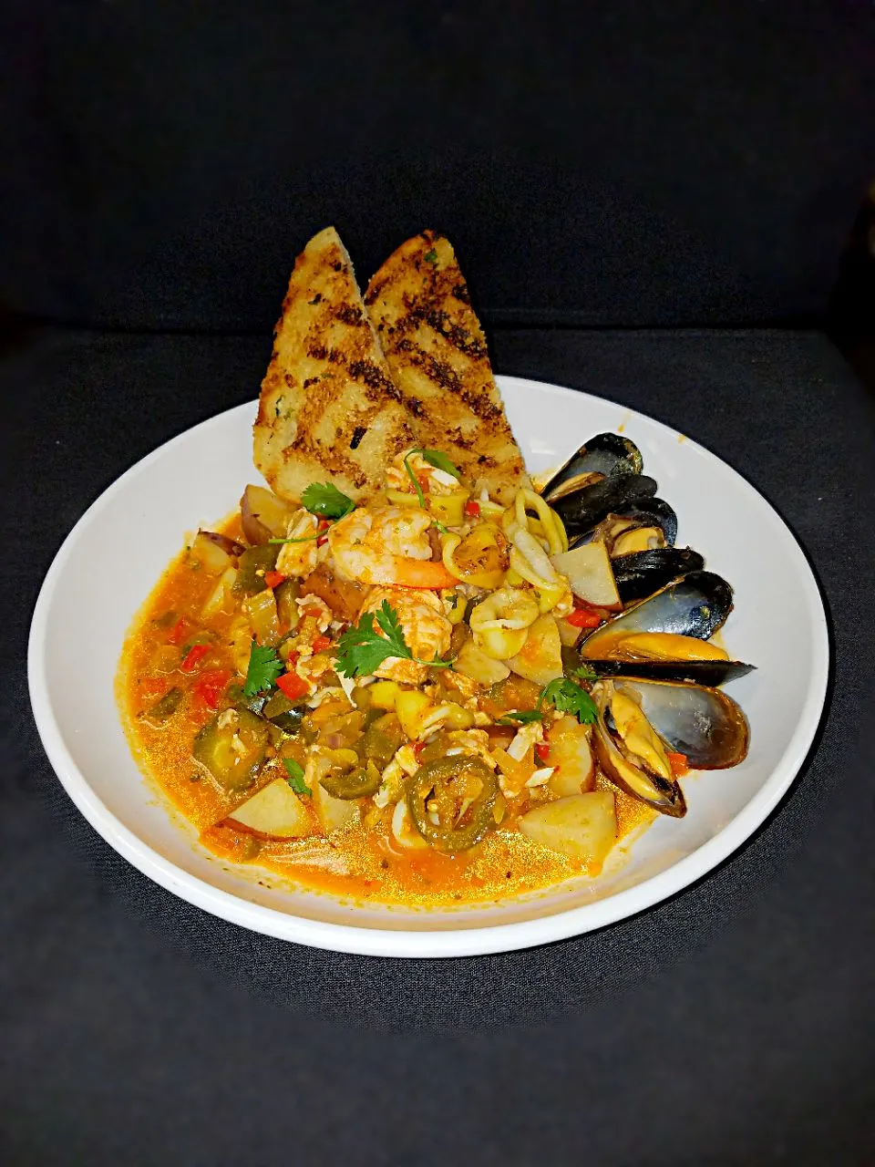 Baja Bouillabaisse with fresh salmon, shrimp, mussels, crab and grilled calamari. With potatoes, Chili's, Olive and it tomato saffron broth. With a side of garl|Melissa Greenさん