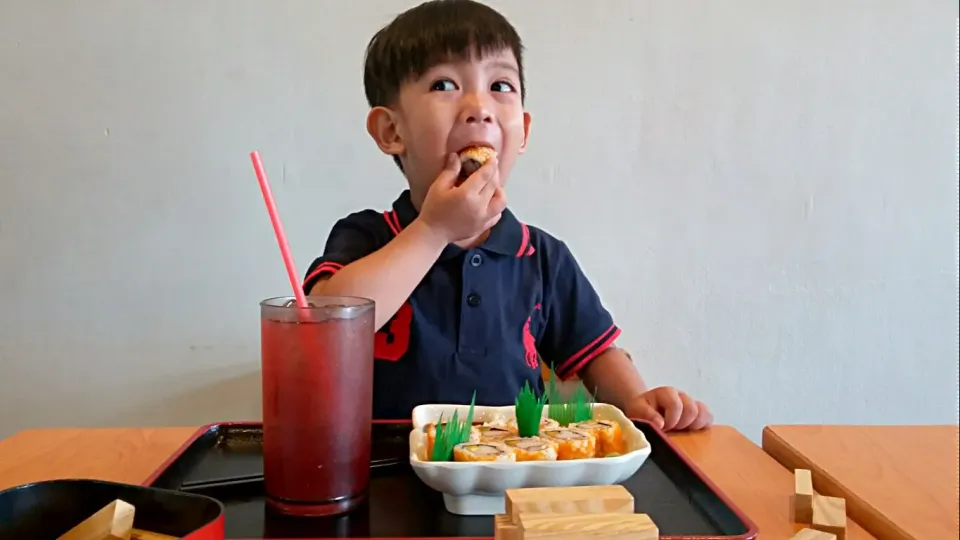 little boy enjoys eating maki sushi|marilou araiさん