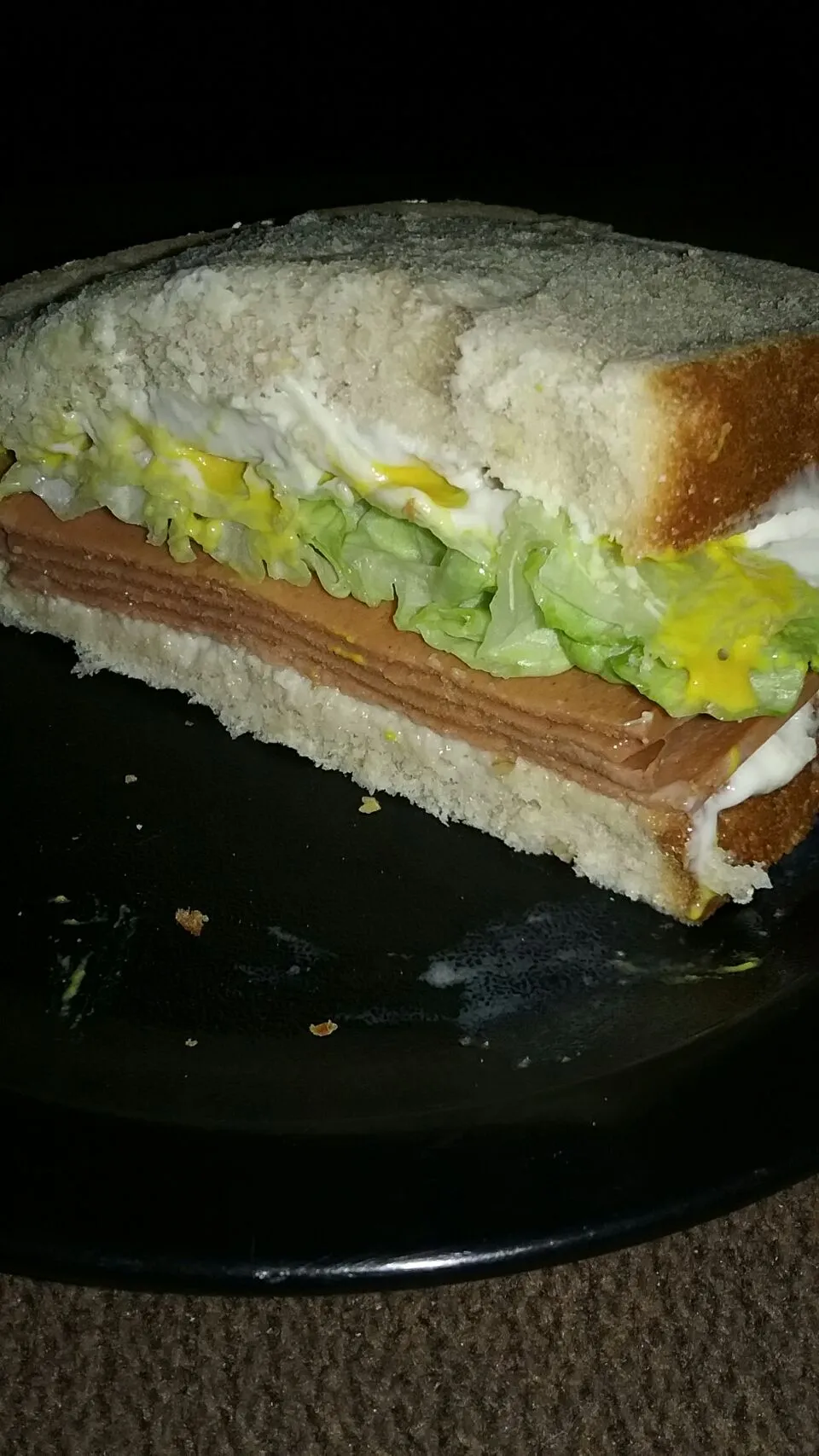 meatless bologna sandwich with mustard,  mayo, lettuce and horseradish on oatnut bread.|Polly Gelfusoさん