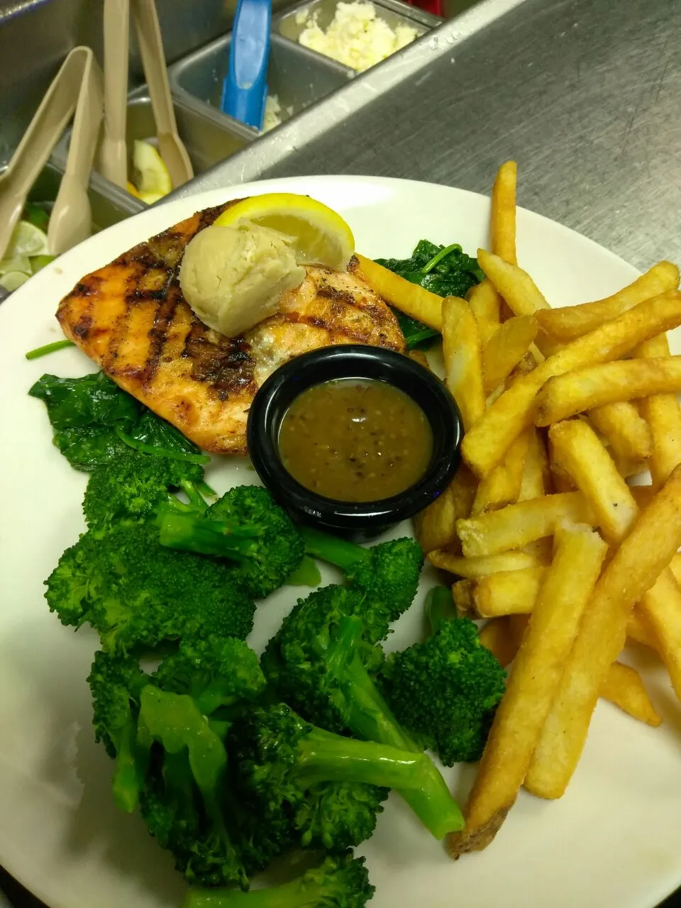 grilled salmon over spinach with broccoli and fries|Polly Gelfusoさん