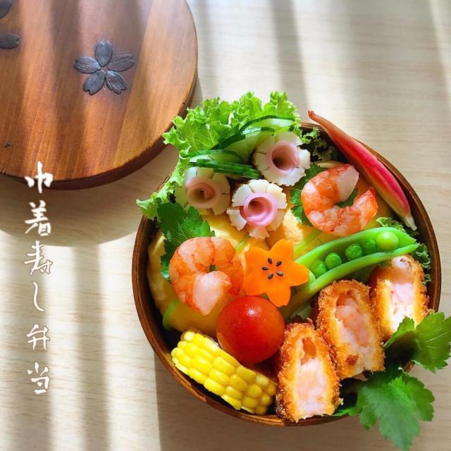 巾着寿司弁当 海老カツ お店のお惣菜 とうもろこし竹輪 真ん中はかまぼこ巾着寿司 エビスナップエンドウミョウガ酢漬け花型にんじんプチトマト