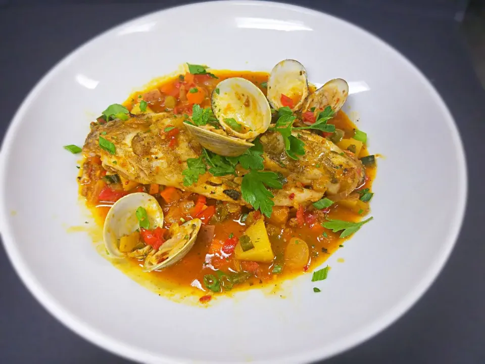 Grilled Wild Rockfish served with chorizo, potatoes, peppers, tomatoes in a clam sauce.|Melissa Greenさん