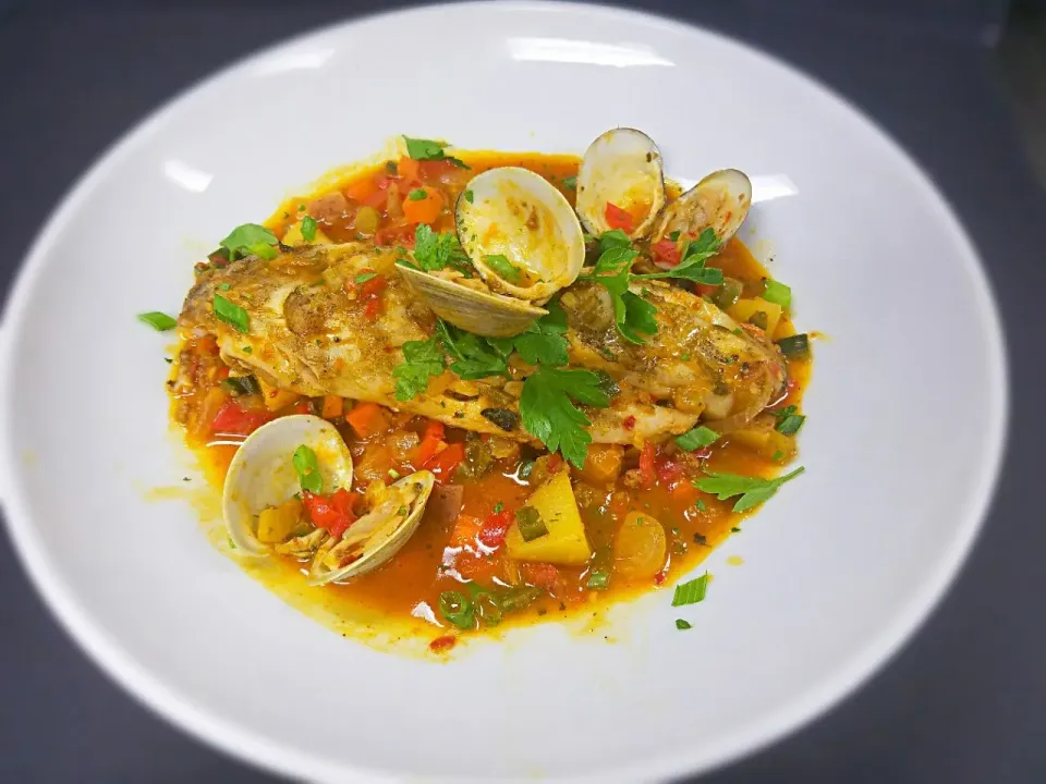 Grilled wild Rockfish. Served with clams, tomatoes, peppers, chrizo amd a clam sauce|Melissa Greenさん