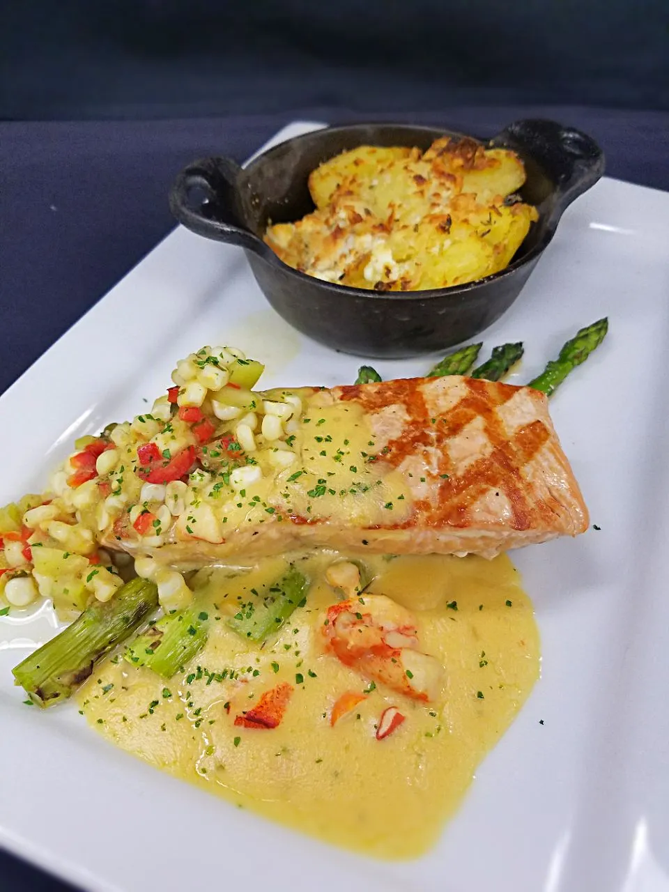 Grilled salmon with twice baked mashed potatoes and asparagus served with a lobster voulette|Melissa Greenさん