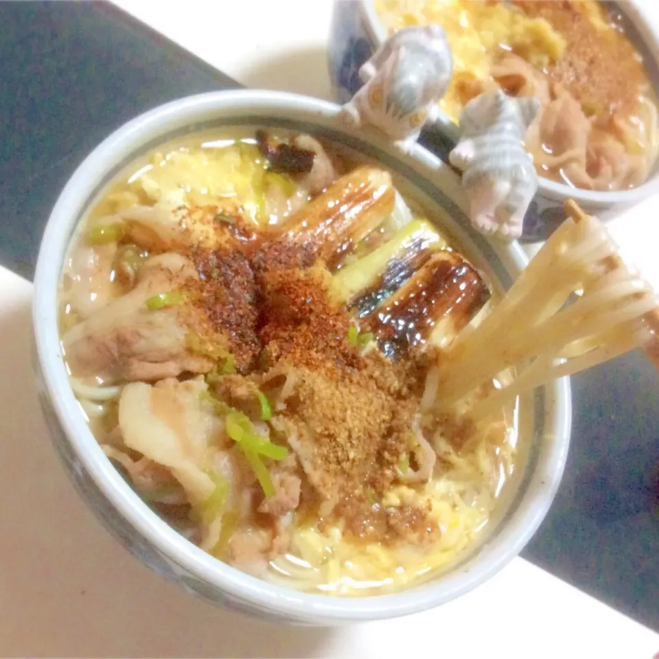 Snapdishの料理写真:昆布だしベースで薄口醤油の透き通ったお汁に、焼きねぎ、しっかり味付けした豚肉、溶き玉子、煎りたてのゴマ、生姜をたっぷりと振りかけた あったまるおうどん。|Takeshi  Nagakiさん