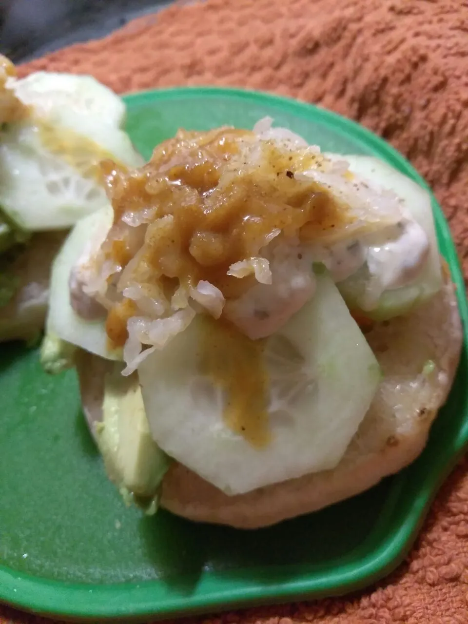 crumpet with avocado, cucs, capers, vegan yummy sauce, celery salt, kraut, and Sriracha pesto.|Polly Gelfusoさん