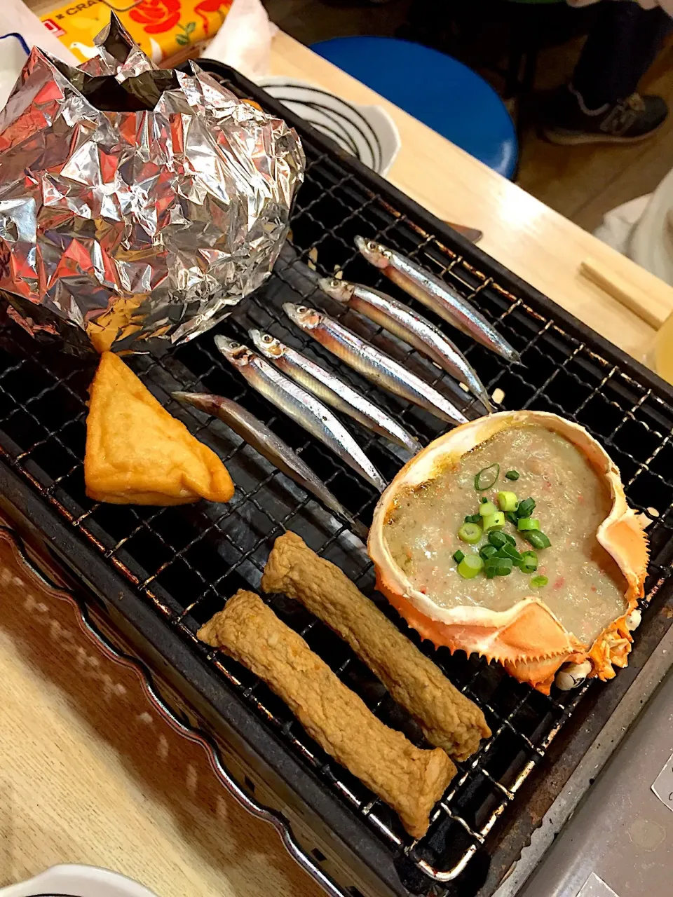 Snapdishの料理写真:お通し（きびなご、さつま揚げ）、蟹味噌甲羅焼@磯丸水産|Kazuya Miyukiさん