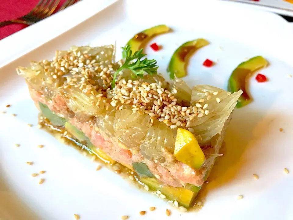 Raw salmon cooked with kumquat dressing in ginger, served on avocado & pomelo layers, sesame crust|Sky Blueさん