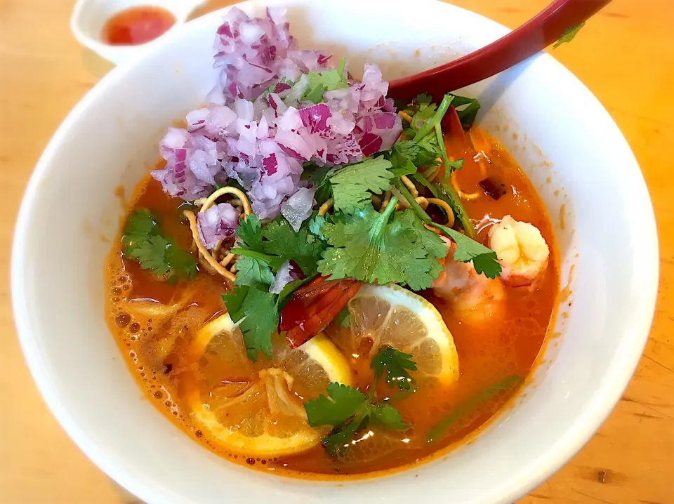 トムヤムラーメン  〜  パクチー、紫玉ねぎ、固揚げそば、エビ、レモンスライスがトッピングされてます。この陽気にはピッタリの一品❗️|リフルシャッフルさん