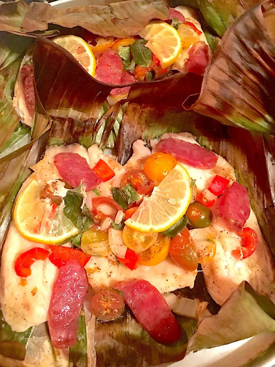 Baked Tilapia in banana leaves topped with tomatoes basil and chinese sausage #chinesesausage  #bakedfishinbananaleaves #tomatobasil|🌺IAnneさん