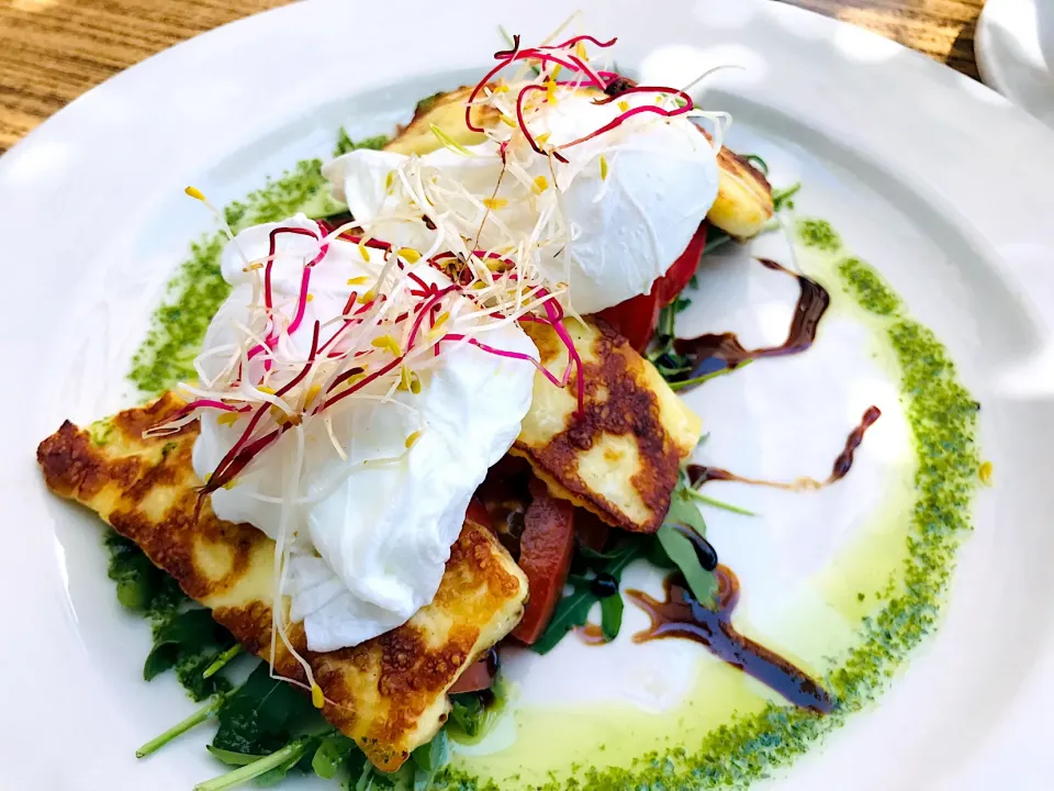 Poached eggs on a bed of halloumi, tomato and rocket.|Sergio Lacuevaさん