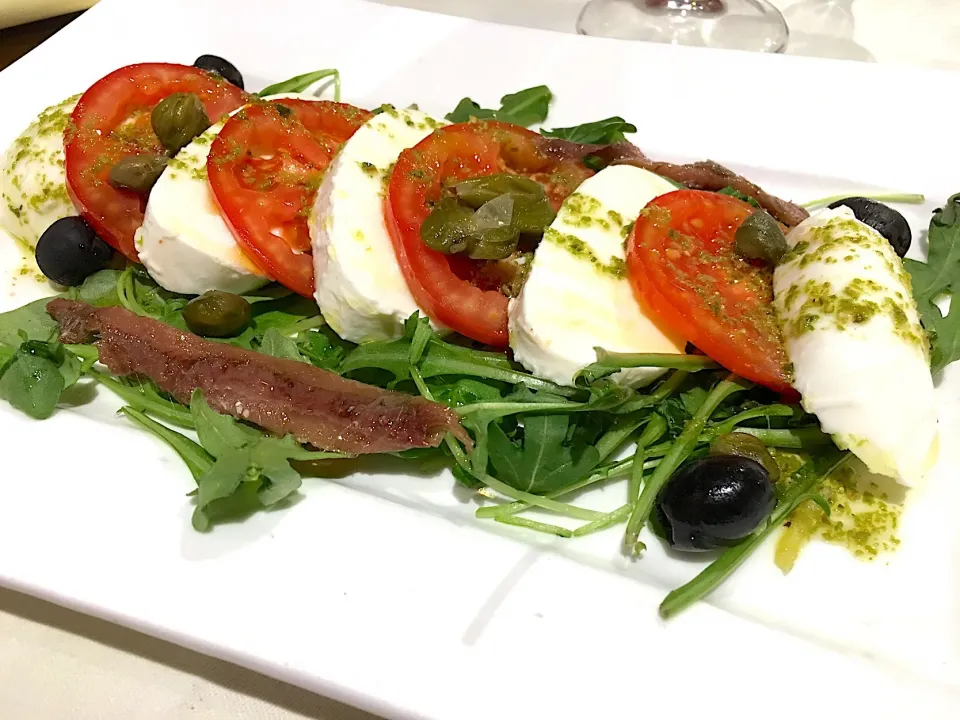 Buffalo mozzarella with tomato and salted anchovies, with olive oil and fresh lime and white soy sauce dressing and capers.|kenさん