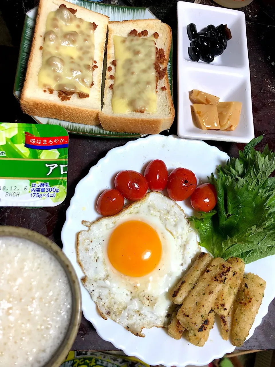 今日の朝ごはん。りんごとバナナのジュース、目玉焼き、ミニトマトのオリーブオイルソテー、大葉、ゴボウの唐揚げ、黒豆！たけのこ土佐煮、チーズトースト（鶏そぼろ乗せ）、ヨーグルト。|岸野 令子さん