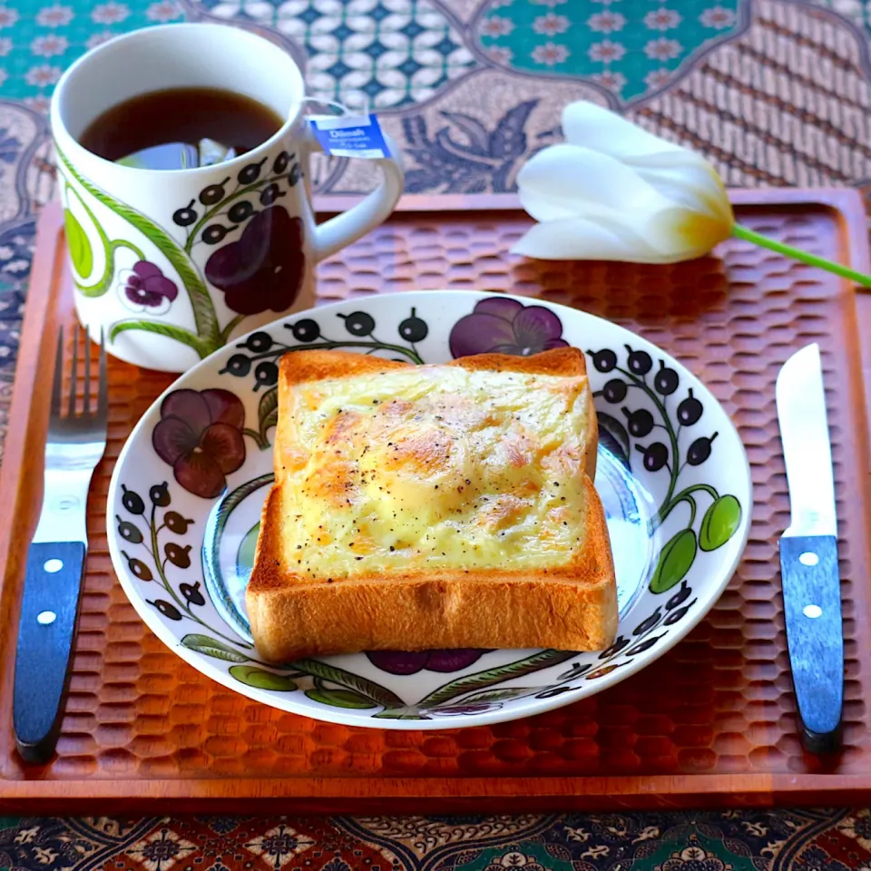 朝ごはん くり抜いたパンにオイルで炒めたキャベツにビネガースタイル を回しかけ和えたものを詰めて  卵を落としてチーズをのせて胡椒ガリガリ|tamiさん