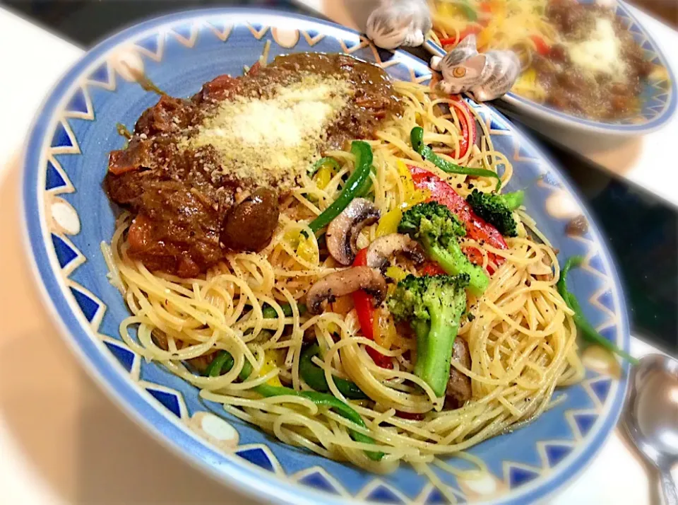 Snapdishの料理写真:連休に作ったカレーの残りでパスタに！
カレーにトマトを🍅入れてソースに、
カラフルパプリカとマッシュでペペロンチーノを作ってカレーをトッピング|Takeshi  Nagakiさん