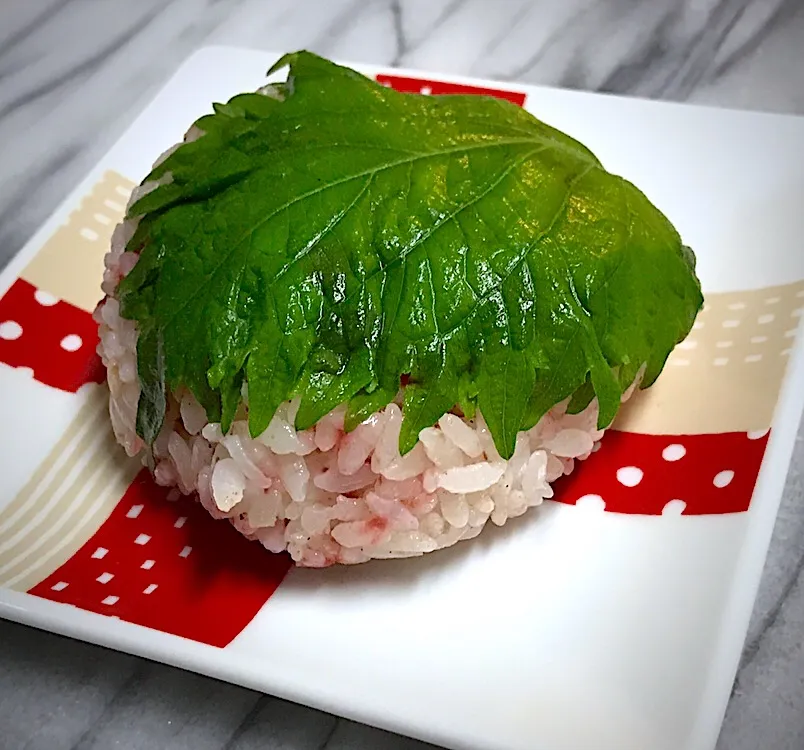 Snapdishの料理写真:禁酒日の夕飯の一品🍙ドライ梅干しまぶしたおにぎりに、海苔の代わりに紫蘇を使ってみましたわ😄|にゃあ（芸名）さん