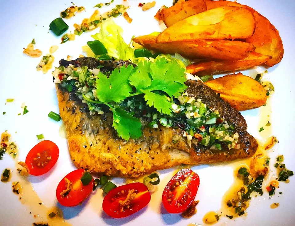 Pan fried seabass with chimichurri, sour lettuce salad and potato wedges.|Jorge Bernal Márquezさん