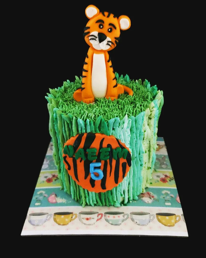 ♡ A tiger theme cake. 

Made of 500gm vanilla sponge. Layered with fresh diced mangoes. Frosted in mango swiss buttercream. Tiger and name plaque hand made with|zakicakesさん