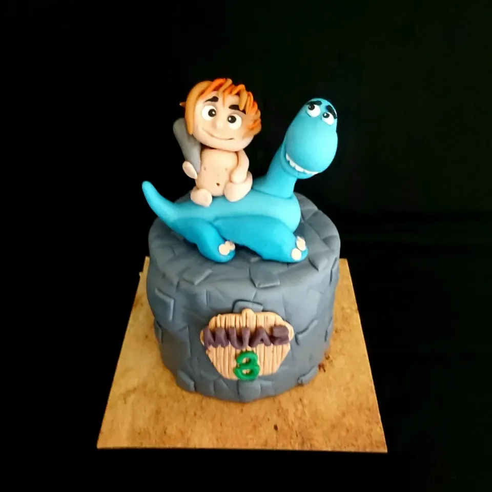 Cave Man & his Blue Dino cake. 

Made of chocolate sponge. Layered in chocolate ganache and crushed Kit Kat. Covered in fondant. Cave man and dinosaur hand made from sugar gumpaste.
|zakicakesさん