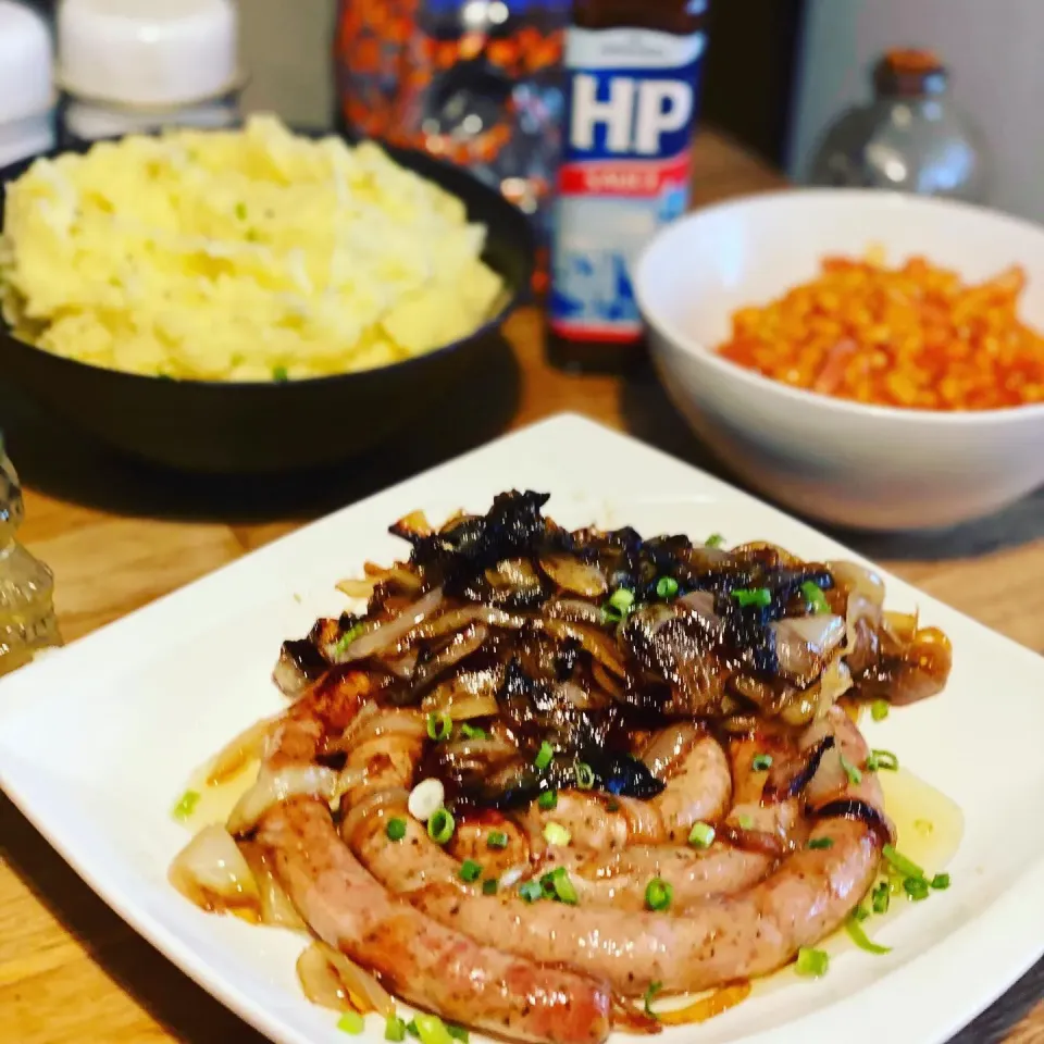 Oh God I had to do It ! Food from the 80s Generation  Ring Fresh Sausage , Fried Onions , Mash Potato , Baked Beans with Bacon  HP Sauce #oldschool  #cafelunch |Emanuel Hayashiさん