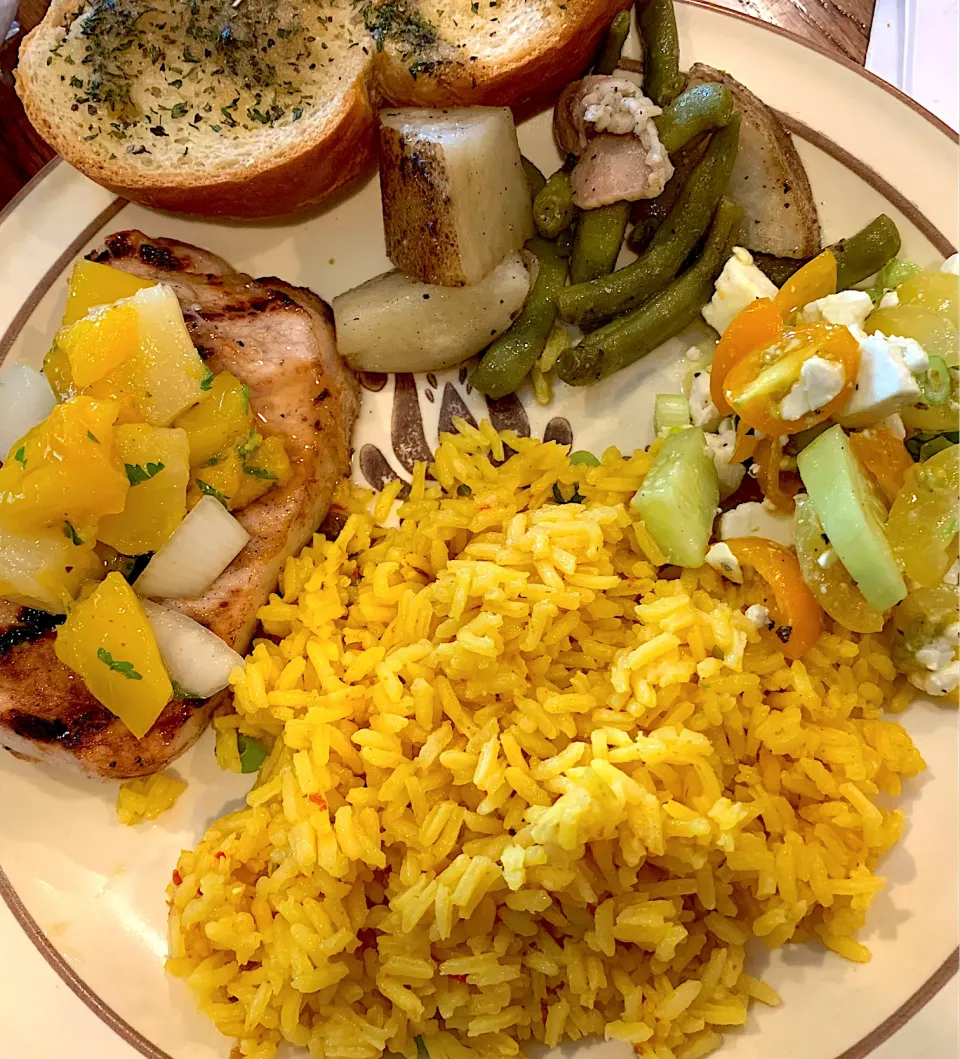 Grilled pork chops with pineapple mango salsa. A marinated tomato cucumber salad and saffron rice|TJ McAfoosさん