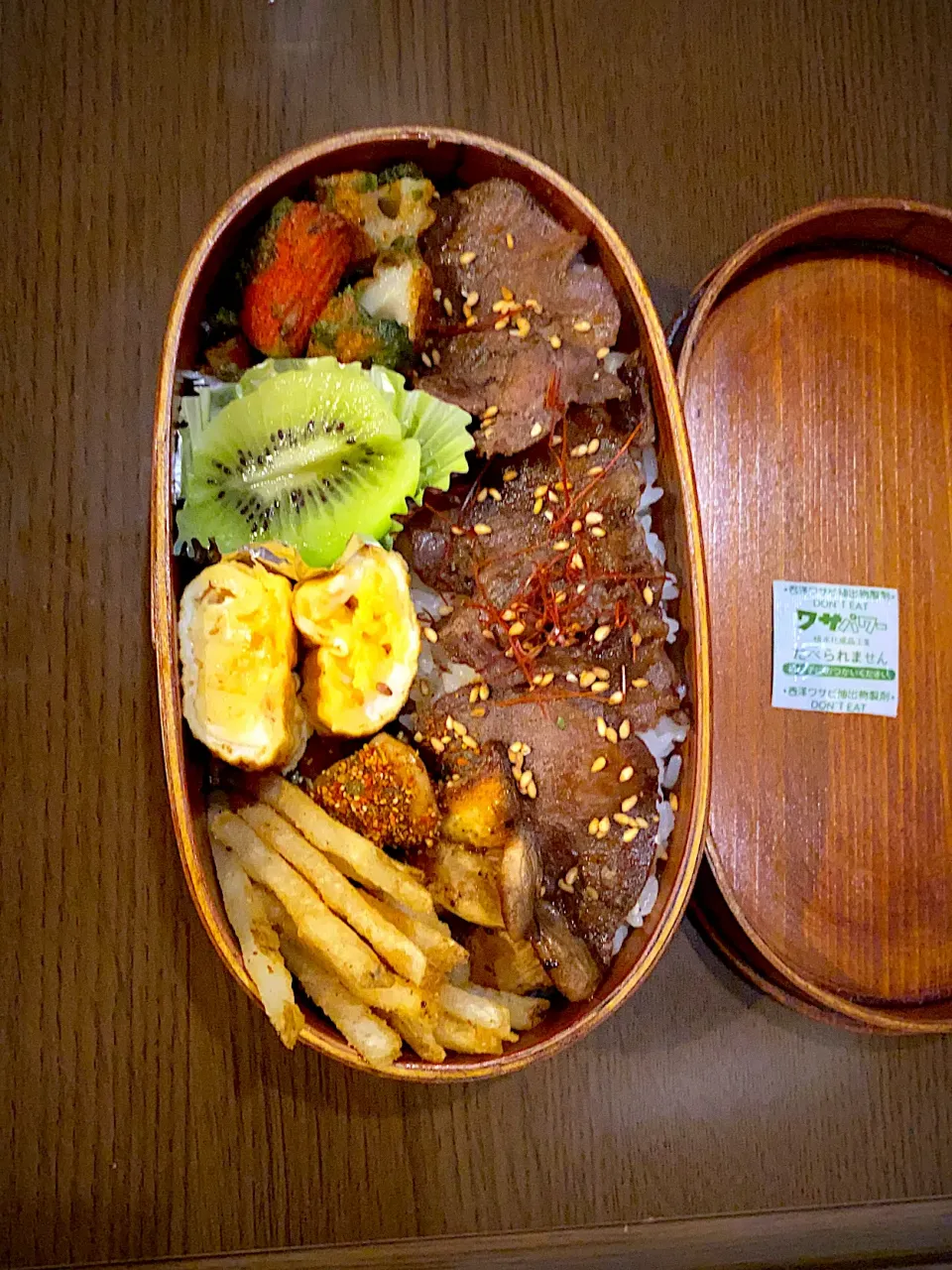 Snapdishの料理写真:お弁当🍱　牛タン焼き肉　糸唐辛子　白胡麻　ガーリックソース　エリンギロースト　帆立ロースト　七味唐辛子　フレンチフライ　　干し海老の出し巻き卵　キウイ🥝　カニかまと竹輪の磯辺揚げ|ch＊K*∀o(^^*)♪さん