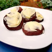 Italian Chocolate Orange Cookies with Orange Icing

ID: A half a dozen chocolate cookies with frosting on top, sitting on a white square plate. The cookies are about two and a half inch wide and a rich, dark, brown from the coca powder. They're puffy and soft. 
The frosting is carelessly swiped on top, making small mountains and valleys across the top. Specks of orange zest peppered throughout, and give the frosting the slightest orange tint. 

In the background, there is a brick path surrounded by greenery.
/End|Sam Hさん