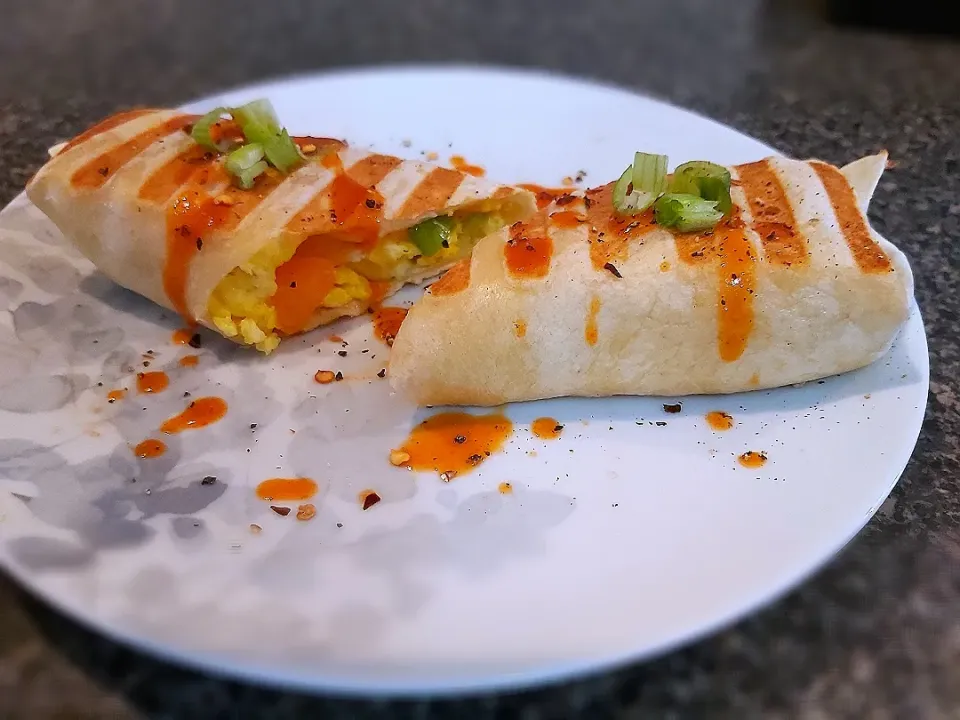 Snapdishの料理写真:BentoFox's dish Scrambled eggs, red & orange bell peppers, chives and grated marble cheese in a lightly grilled wrap topped with a spicy Cholula sauce and black pepper 👌|BentoFoxさん