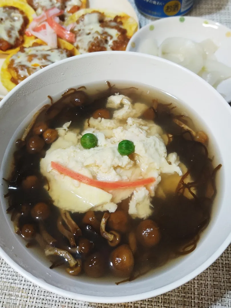 モズクとナメコ入りゆし豆腐

この料理は私の好物ではありますが、色がいけません。
なにせ、焦げ茶色なのです。
見た目が「キレイ！映える！」とはなりません。
では、グリーンピースと紅ショウガで顔を描いてみましょうか。
あまり変わりませんね。|Rピージャーさん