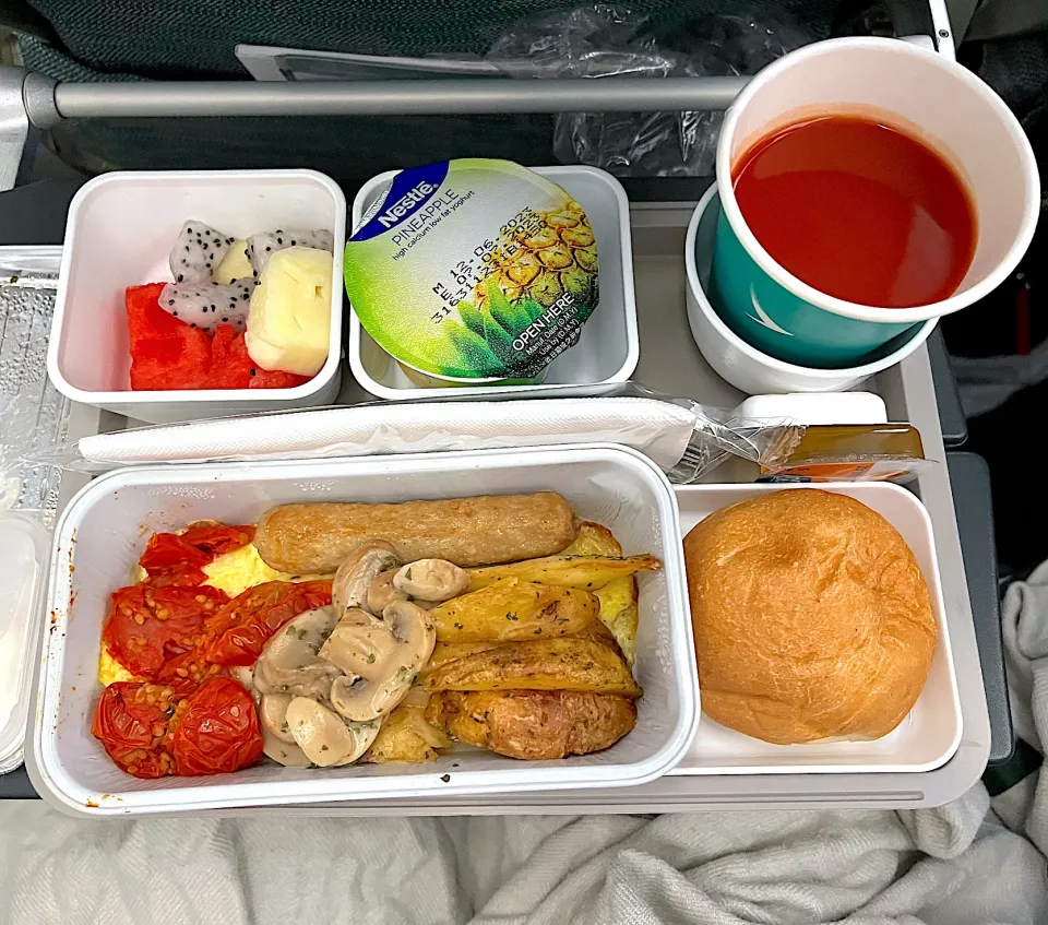 Scrambled eggs with tomatoes, potatoes, sausage and mushrooms, bread, yogurt, bread, fruits and tomato juice|skyblueさん