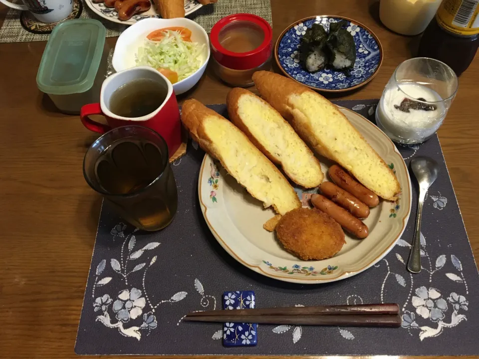 Snapdishの料理写真:ガーリックトースト、揚げ焼きコロッケ、ウインナー炒め、サラダ、沢庵、スープ、六条麦茶、カシスジャム入りヨーグルト(昼飯)|enarinさん