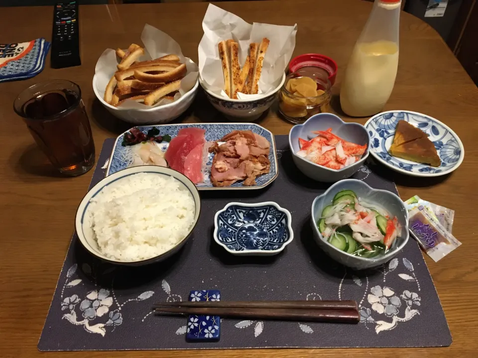 Snapdishの料理写真:ご飯、めばちまぐろの切り落とし、つぶ貝のお造り、つるし焼き豚スライス、カニカマときゅうりの酢の物、カニカマ、沢庵、甘い揚げパンとガーリック揚げパン、烏龍茶、卵ケーキ(夕飯)|enarinさん