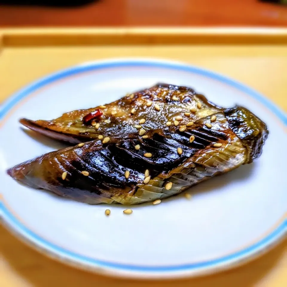 おかっぱナスの焼き煮

とろとろで甘辛い醤油味のどこか懐かしい味🌳

おいしいのに、和食にするとなんだか垢抜けないナスをちょっぴり【おめかし】してみました🍆

ナスの変色しやすさを逆手に取り、ステンレスの鍋で落し蓋を使いながら少量の油で焼き目をつけるとこんなにきれいなグラデーションに✨

出汁は使わずナスの水分と少量の水で煮ると軽い口当たりになり春夏シーズンに適しています☺

普段の副菜だけではなく、お酒のおつまみにも◎

キンと冷やして味が染み込んだときが最高の食べ頃です💫|森のごはん屋さんさん