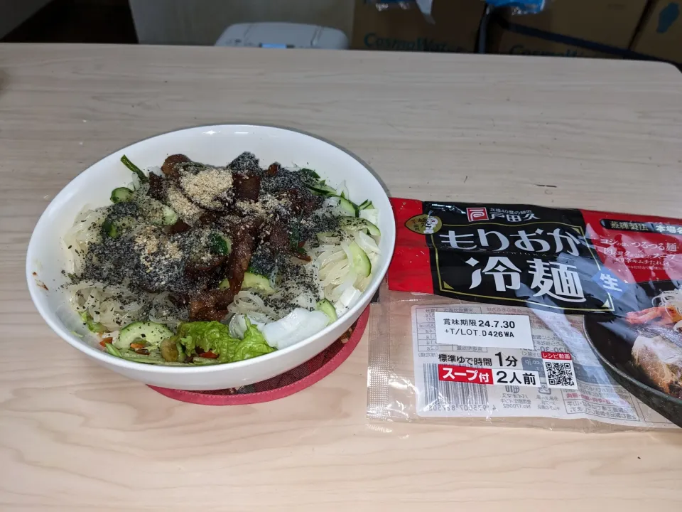 Snapdishの料理写真:2024/05/27の食事も屋内でサラダ麺シリーズは市販のピリ辛もりおか冷麺をベースに
・特製豚焼き肉トッピングもりおか冷麺
具材等（市販の常温保存のもりおか冷麺＋25日作成の豚肉＋玉葱＋玉葱の芽＋胡瓜＋キューピーさらたくらぶ緑黄色野菜＋セブンの千切りキャベツ＋丸本太白胡麻油＋太香胡麻油＋白黒すり胡麻）|Tarou  Masayukiさん