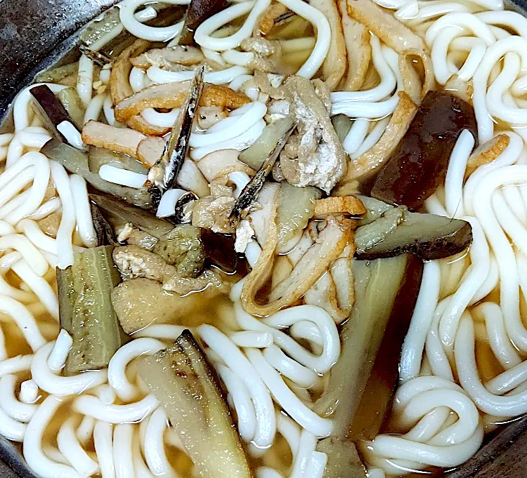 うちの田舎の郷土料理的な大鍋うどん◥█̆̈◤࿉∥ こちらはこしのある太麺を嫌います 丸麺で柔らかく噛まずに喉にツルツル入るうどんが主流です イリコで出汁を取り油揚げと天ぷら（じゃこ天みたいな魚肉の練り物）と🍆を具材に作る昔ながらのうどん◥█̆̈◤࿉∥です 🍆、天ぷら、油揚げから良い出汁が出てイリコの出汁に更にコクを|🐈⸒⸒⸒⸒つるのダンス🐈🐾さん