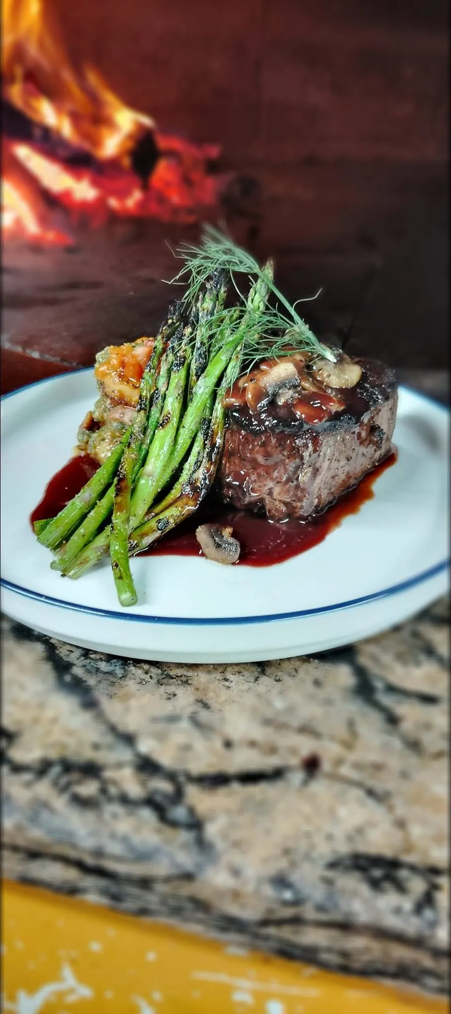 8oz Prime filet topped with sauteed mushrooms and a cabernet port demi glace served along side a stack of fried polenta cakes with pistachio pesto and tomato ba|Matt Burleighさん