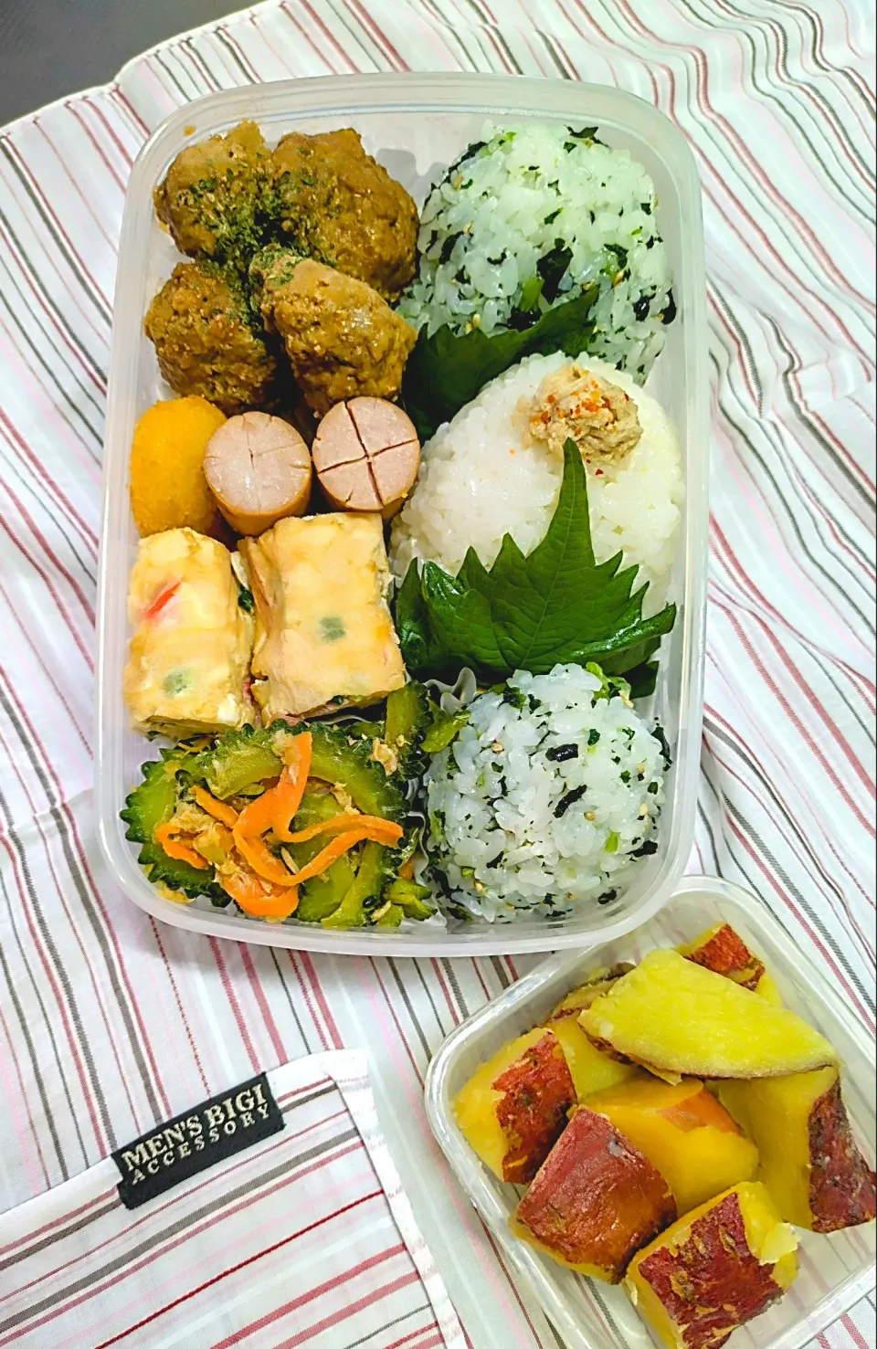 Snapdishの料理写真:本日の日替わり弁当

①おにぎり（若菜・ツナマヨ）
②自家製ミートボール
③ポキポキウインナー
④コーンクリームフライ
⑤いつもの厚焼きたまご（かにかま・青ネギ）
⑥ゴーヤー炒め
⑦さつまいもレモン煮|TakeBooさん