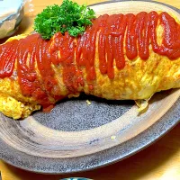 野菜たっぷりチキンライスを【どデカオムライス】に チキンライスには昨日使った鶏むね肉の残り、ピーマン、人参、椎茸、モロッコインゲン、庭採れパセリ、卵4つ、ご飯3合、ご飯を炊く時に【日清さらっと軽～いオリーブオイル】を少し入れて炊くと焼き飯やチキンライス、炒飯がパラッと仕上がります【日の出新味料】も使用| 🐈⸒⸒⸒⸒つるのダンス🐈🐾さん