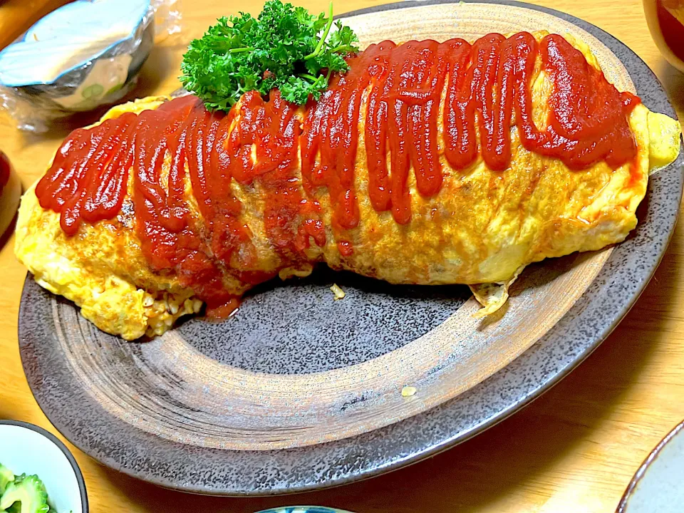 野菜たっぷりチキンライスを【どデカオムライス】に チキンライスには昨日使った鶏むね肉の残り、ピーマン、人参、椎茸、モロッコインゲン、庭採れパセリ、卵4つ、ご飯3合、ご飯を炊く時に【日清さらっと軽～いオリーブオイル】を少し入れて炊くと焼き飯やチキンライス、炒飯がパラッと仕上がります【日の出新味料】も使用|🐈⸒⸒⸒⸒つるのダンス🐈🐾さん