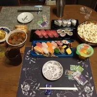 12貫入り握り寿司、鯖の押し寿司、鮪づくしの握り寿司と太巻き、ポップコーン・塩、じゃがバター、チーズ揚げ、もつ煮込み,沢庵、六条麦茶、フルーツゼリー(夕飯)|enarinさん